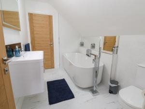 ein Badezimmer mit Badewanne, Waschbecken und Toilette in der Unterkunft Kerry Cottage in Holywell + 21 Fotos