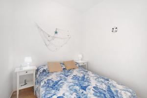 Schlafzimmer mit einem Bett mit einer blauen und weißen Bettdecke in der Unterkunft Atico Las Arenas in Arico