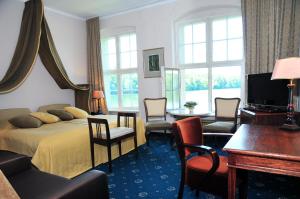 ein Hotelzimmer mit einem Bett, einem Tisch und Stühlen in der Unterkunft Zamek Podewils Krag in Krąg