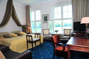 pokój hotelowy z łóżkiem, stołem i krzesłami w obiekcie Zamek Podewils Krag w mieście Krąg