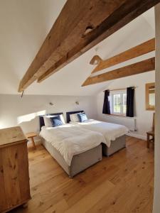 1 dormitorio con 1 cama grande y suelo de madera en The Hayloft, en Lincolnshire