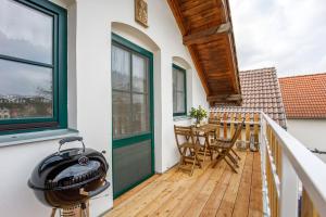 a balcony with a grill and a table and chairs at Vinařský apartmán Špalek in Nový Šaldorf