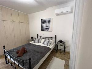 a bedroom with a bed and a picture of a woman at The Best prime location lovely 1 bedroom apartment in Paphos City