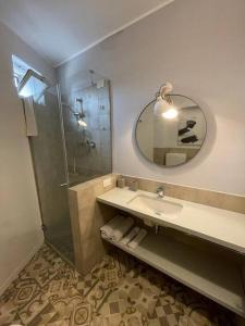 uma casa de banho com um lavatório e um chuveiro com um espelho. em Appartamento Stadio em Cremona