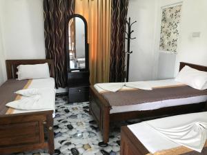 ジャフナにあるGreen star villaのベッド2台と鏡が備わる客室です。