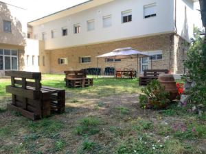 a group of chairs and an umbrella in front of a building at San Giuseppe Casa per Ferie in Quercianella