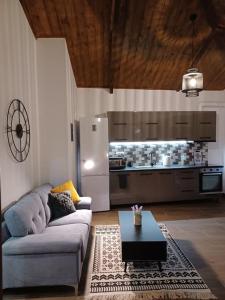 a living room with a couch and a kitchen at Luxury Apartment with balcony in Mytilini