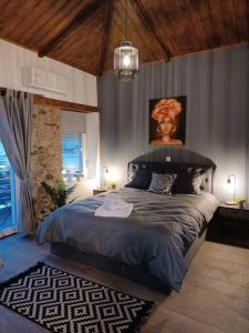 a bedroom with a large bed with a painting on the wall at Luxury Apartment with balcony in Mytilini