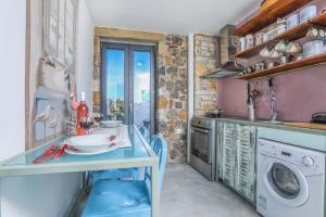 a kitchen with a table and a washing machine at Casa Pietra in Kontokali