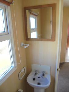 a bathroom with a sink and a mirror at 6 Berth Sealands Ingoldmells Central heated (Carlton) in Ingoldmells