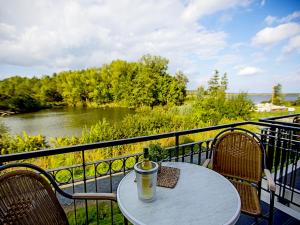 a table and chairs on a balcony with a view of a river at Residenz am Balmer See - BS 55 mit Wellnessbereich in Balm