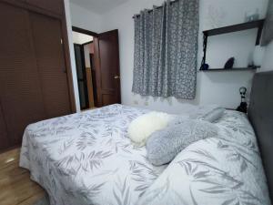 a bedroom with a bed with a white comforter at Awesome Apartment in Puerto del Rosario