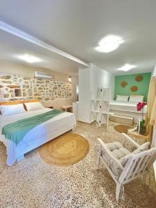 Afiartis Avli House في كارباثوس: غرفة نوم بسرير وكرسي وأريكة