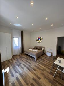 una camera con letto e pavimento in legno di Gata Galleria Taranto a Taranto