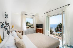 a bedroom with a bed and a view of the ocean at Oliveto Capri apartments in Capri