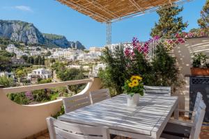 einen Tisch auf dem Balkon mit Stadtblick in der Unterkunft Oliveto Capri apartments in Capri