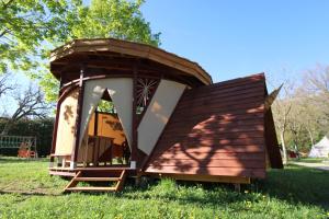 uma pequena casa está sentada na relva em Habitat Créateur - Hébergements insolites au camping municipal "Les Ecureuils" em Recoubeau