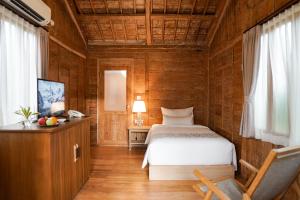 une chambre avec un lit, un bureau et une chaise dans l'établissement Ijen Estate Resort And Villa, à Banyuwangi 59 autres photos