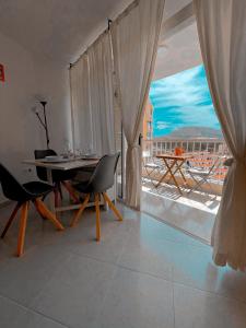 a dining room with a table and a large window at TwinTorres LasAmericas in Playa de las Americas