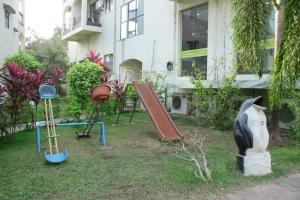 un patio con parque infantil frente a un edificio en Royale Assagao Resort, en Assagao