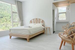 una camera bianca con un letto e una sedia di 埔里-阮兜小丘 a Puli