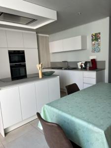 uma cozinha com mesa e cadeiras e uma cozinha com armários brancos em MORI em Bruges