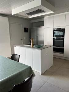 a kitchen with white cabinets and a table with chairs at MORI in Bruges