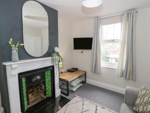 ein Wohnzimmer mit einem Kamin und einem Spiegel in der Unterkunft Dobbies Den in Bewdley