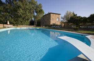 una grande piscina con un edificio sullo sfondo di Borgo San Lorenzo a Linari a San Rocco a Pilli