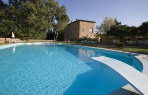 a large swimming pool with a building in the background at Residence Borgo San Lorenzo a Linari in San Rocco a Pilli