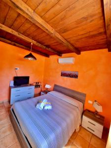 a bedroom with a bed and a tv and orange walls at Acquamarina in Gaeta