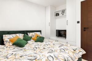 sypialnia z łóżkiem z 2 zielonymi poduszkami w obiekcie 2 apartamenty typu premium tylko 9 minut do Jeziora Tarnobrzeskiego oraz 15 minut od Sandomierza !!! w Tarnobrzegu
