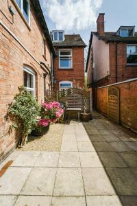 un patio de un edificio de ladrillo con una mesa y flores en Emerald Stays UK at The Adelphi en Stratford-upon-Avon