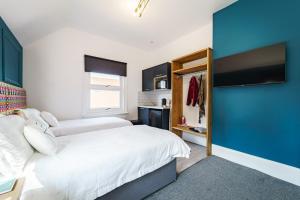 um quarto com 2 camas e uma parede azul em Emerald Stays UK at The Adelphi em Stratford-upon-Avon