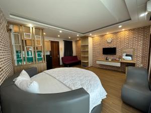 a bedroom with a white bed and a television at The Land Hotel & Apartment in Vung Tau