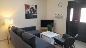 a living room with a couch and a tv at Captains View Apartments in Plati