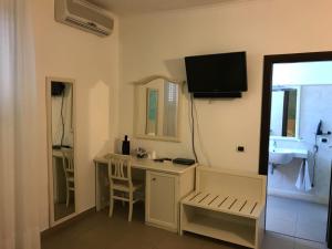baño con lavabo y escritorio con TV en la pared en Pescasubacquea, en Crotone