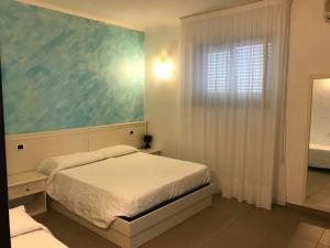 a small bedroom with a bed and a window at Pescasubacquea in Crotone +37 photos