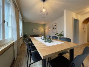 No.8 Boutique Apartment في Unterseen: غرفة طعام مع طاولة وكراسي خشبية كبيرة