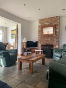 a living room with a table and a fireplace at Bainvalley Cottages peaceful South Cottage in Lincolnshire