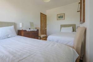 a bedroom with two white beds and a dresser at Bainvalley Cottages peaceful South Cottage in Lincolnshire
