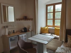 ein kleines Wohnzimmer mit einem Tisch und einem Fenster in der Unterkunft Zimmer Donaustrand in Leiben