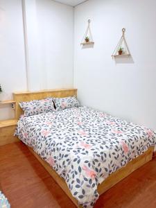 1 dormitorio con 1 cama con edredón de flores en Suri's House Homestay, en Da Lat