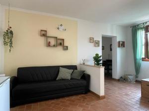 a living room with a black couch in a room at Casa Desi in Baura