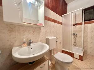 een badkamer met een witte wastafel en een toilet bij Apartmani Zeleni Raj in Dramalj