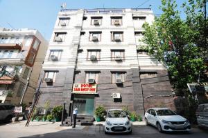 a white building with cars parked in front of it at Hotel S & B East Inn - Patel Nagar in New Delhi