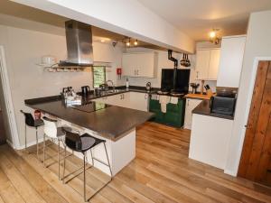 a kitchen with white cabinets and a black counter top at Lee House Cottage in Cheddleton
