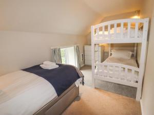 1 dormitorio con 2 literas y espejo en Lee House Cottage, en Cheddleton