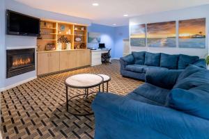 uma sala de estar com sofás azuis e uma lareira em Hotel Carolina A Days Inn by Wyndham em Hilton Head Island