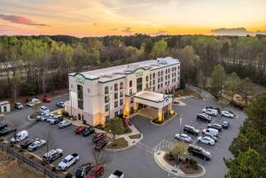 eine Luftansicht eines Gebäudes mit einem Parkplatz in der Unterkunft Wingate by Wyndham State Arena Raleigh/Cary Hotel in Raleigh